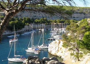 Sailboats in a harbour surrounded by stone bluffs